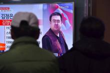 Des personnes regardent la télévision diffusant des informations concernant l'assassinat de Kim Jong