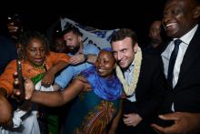 Emmanuel Macron (2eD) pose pour un selfie avec une femme et le maire de Dzaoudzi Said Omar Oili (D) 