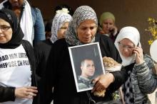 La mère d'Imad Ibn Ziaten, avec une photo de son fils, lors d'une marche silencieuse le 24 mars 2011