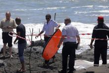 Un policier emporte le bodyboard du jeune homme tué par un requin le 21 février 2017 à Saint-André à