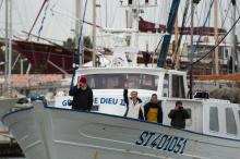 Marine Le Pen fait un signe de la main lors de sa virée sur un bateau de pêche au Grau-du-Roi, dans 