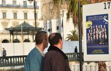 Des Algériens regardent les affiches électorales lors de la campagne pour les élections législatives