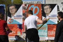 Des militants de "La France Insoumise" collent des affiches de leur candidat, Jean-Luc Mélenchon, le