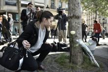 Un femme dépose une fleur sur les Champs Elysées, le 21 avril 2017, au lendemain de la mort d'un pol