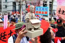 Un supporter du parti Kuomintang porte une statuette de l'ancien leader nationaliste Chang Kai-shek,