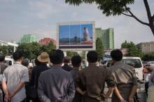 Des nord-coréens regardent un écran diffusant des informations sur le lancement d'un missile balisti