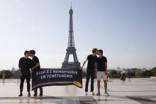 Des militants d'Amnesty s'embrassent devant la tour Eiffel à Paris dans le cadre d'une manifestation