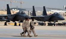 Des officiers de l'armée saoudienne passent devant les avions de combat F-15, des bombes GBU et des 