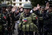 Des soldats philippins participent au hissage du drapeau à Marawi, dans le sud, le 12 juin 2017