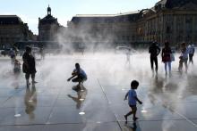 Des gens se rafraîchissent à une fontaine à Bordeaux le 19 juin 2017