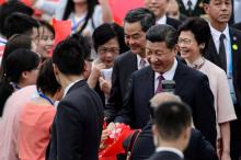 Le président chinois Xi Jinping (c) et sa femme Peng Liyuan (d) à leur arrivée à l'aéroport de Hong 