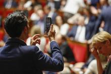 Un député prend une photo avec son téléphone portable lors de la session inaugurale de la XVème légi