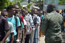 De jeunes postulants font la queue pour passer des entretiens de recrutement de soldats à Léogane, à