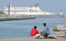 Des migrants afghans regardent passer un ferry près du port de Calais, le 19 septembre 2009