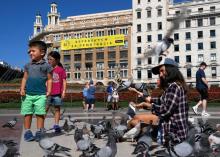 Sur cette photo prise le 13 septembre 2017 sur la place de Catalogne à Barcelone, une femme et des e