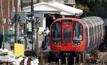 Des policiers inspectent la rame de métro dans laquelle une bombe à explosé à Londres, le 15 septemb