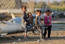 Des enfants syriens jouent sur un missile abandonné dans le camp de réfugiés d'Ash'ari, dans la zone