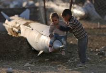 Des garçonnets jouent sur un missile abandonné dans le camp de réfugiés de Ghouta proche de Damascus