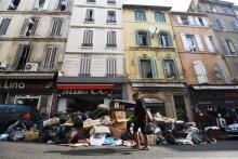 Une femme marche devant une pile d'ordure à Marseille le 13 octobre 2017