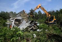 Un bulldozer détruit une maison de fortune le 17 mai 2018 lors de la deuxième opération d'expulsion de la ZAD de Notre-Dame-des-Landes (Loire-Atlantique)