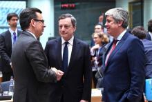 Le président de la Banque centrale européenne Mario Draghi (centre), entouré du ministre espagnol des Finances Roman Escolano (G), et du président de l'Eurogroupe, le Portuguais Mario Centeno lors de 
