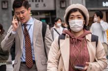 Des Japonais dans le quartier de Shibuya à Tokyo, le 13 mars 2023, premier jour d'un allègement des